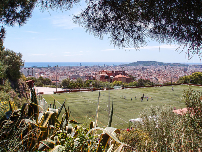 Barcelona city panorama, green football fileld, park Montjuic, passeig auigues