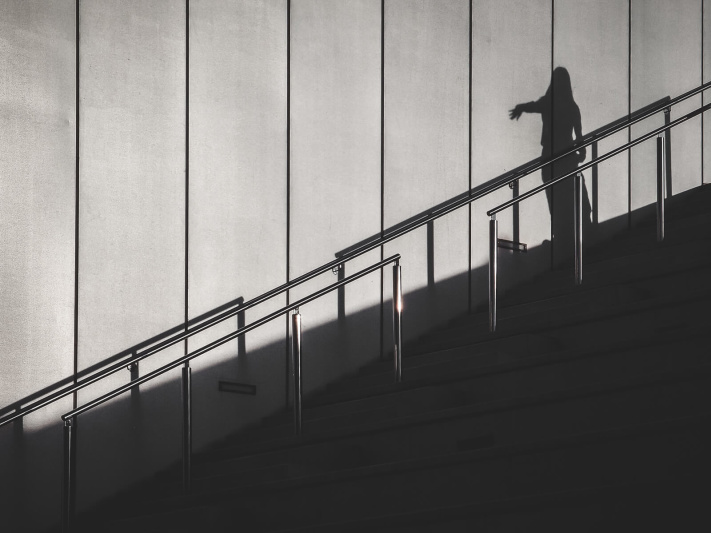 Barcelona, fingers pointing, outdoor stairs, shiny handrail, silver gray background, theatrical act, woman silhouette