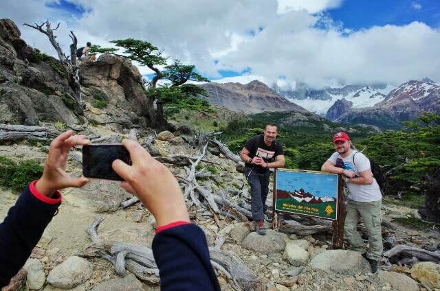 El Chalten people posing for a photo by the Firtz roy sign